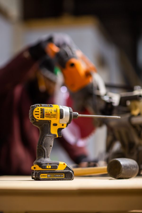 A yellow cordless impact driver on a workbench