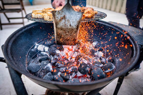 Glowing coals in a round charcoal barbecue